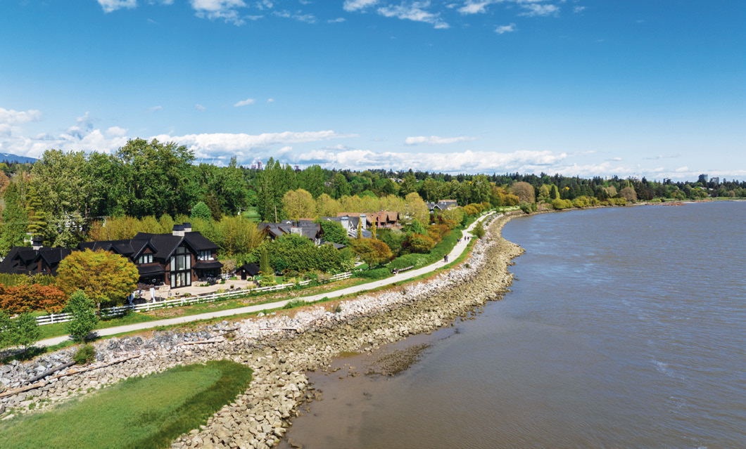 Waterfront view showing homes along the Fraser River with walking path
